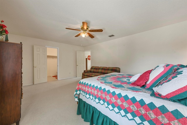 carpeted bedroom with ceiling fan and a textured ceiling