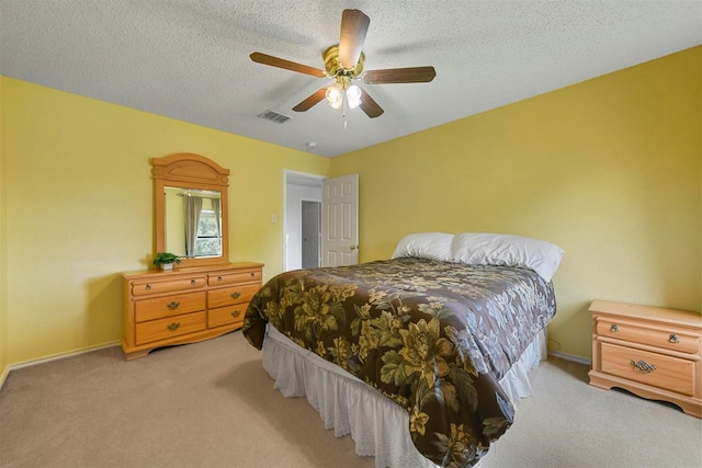 carpeted bedroom with ceiling fan and a textured ceiling