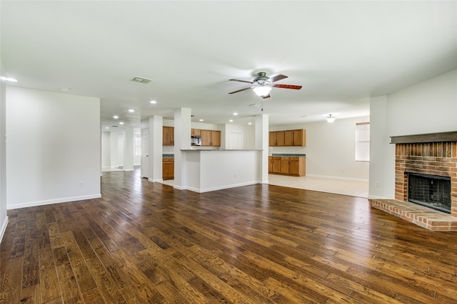 unfurnished living room featuring a fireplace, hardwood / wood-style floors, and ceiling fan