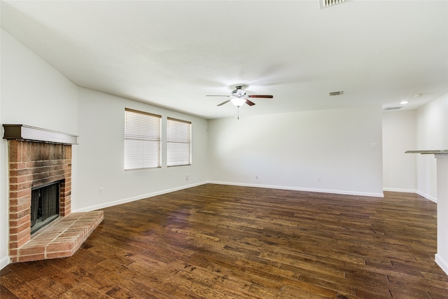 unfurnished living room with a fireplace, dark hardwood / wood-style floors, and ceiling fan