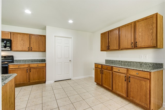 kitchen featuring black appliances, light tile patterned flooring, and stone counters