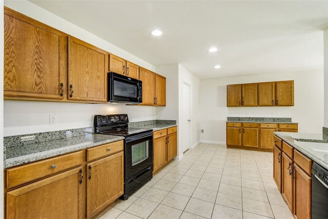 kitchen with light stone countertops, light tile patterned floors, and black appliances