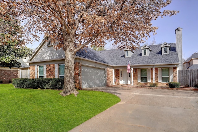 view of front of house with a front lawn, fence, concrete driveway, an attached garage, and brick siding