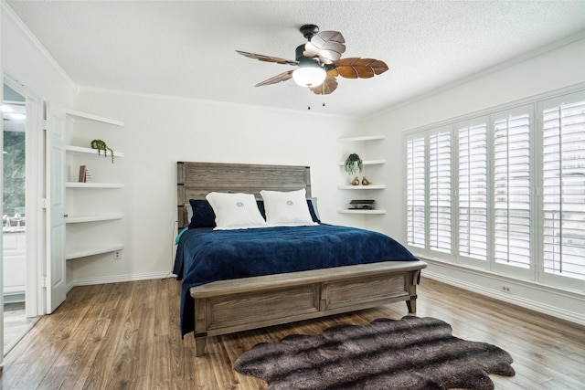 bedroom featuring multiple windows, a textured ceiling, wood finished floors, and crown molding