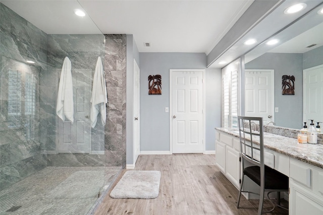 bathroom with a walk in shower, wood finished floors, recessed lighting, baseboards, and vanity