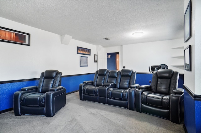 home theater featuring visible vents, a textured ceiling, and carpet flooring