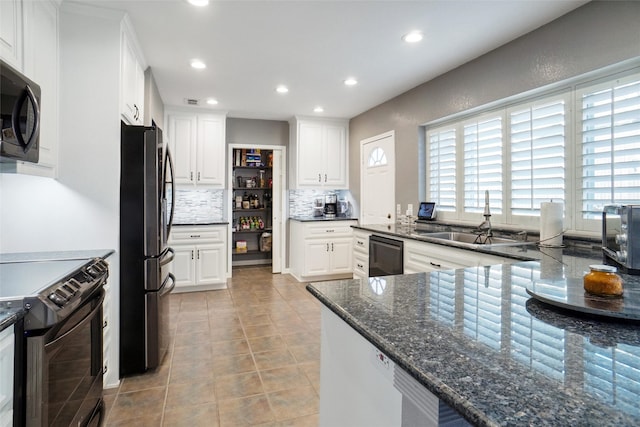 kitchen with tasteful backsplash, sink, dark stone countertops, white cabinets, and black appliances