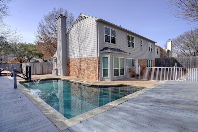 view of pool featuring a wooden deck, a fenced in pool, and fence