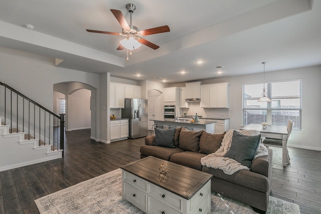 kitchen featuring appliances with stainless steel finishes, ventilation hood, a kitchen island with sink, sink, and white cabinetry