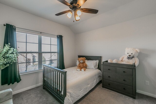 carpeted bedroom featuring a nursery area and ceiling fan