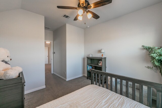 carpeted bedroom featuring ceiling fan and a crib