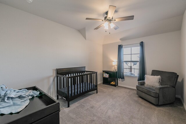 bedroom with ceiling fan, light colored carpet, lofted ceiling, and a nursery area