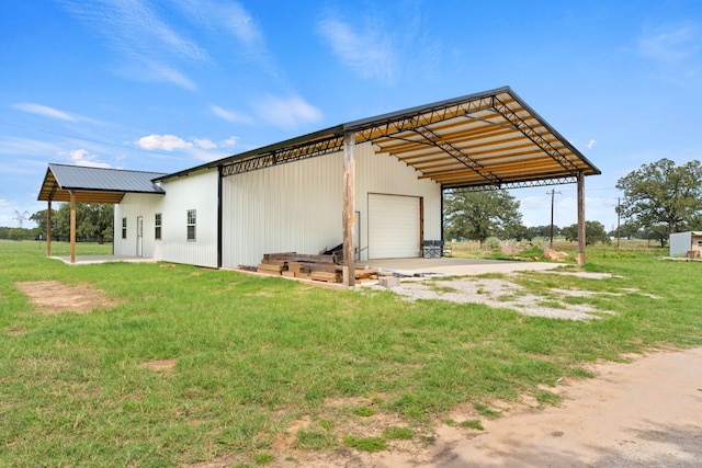 rear view of property featuring an outbuilding, a garage, and a lawn