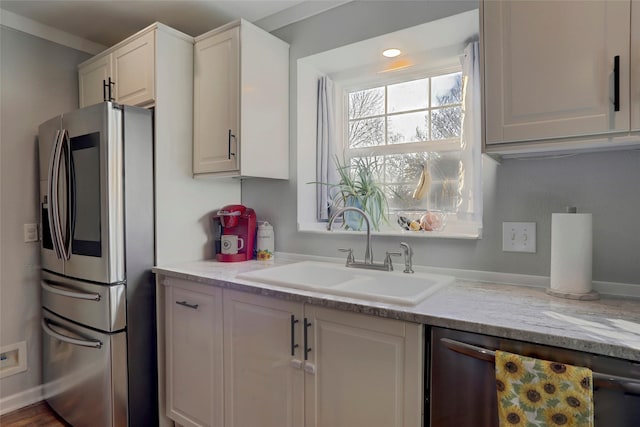 kitchen with white cabinets, light stone counters, sink, and appliances with stainless steel finishes