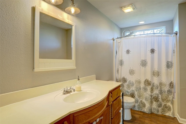 full bathroom featuring hardwood / wood-style floors, vanity, toilet, and shower / bath combo