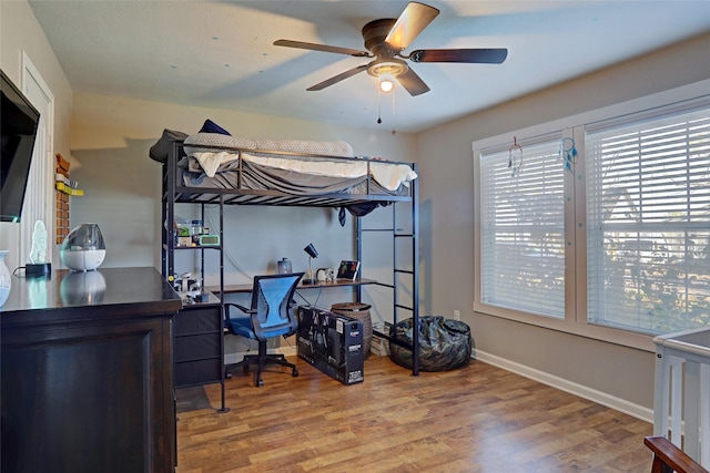 bedroom featuring hardwood / wood-style flooring, ceiling fan, and white fridge