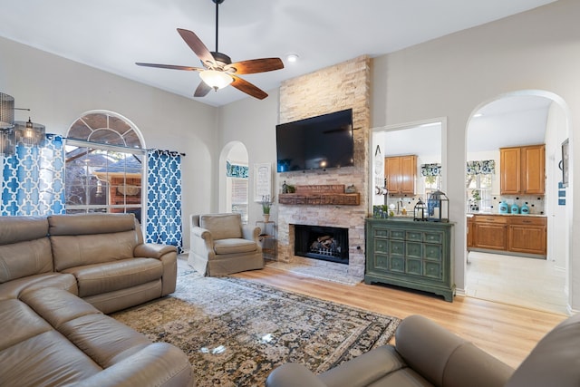 living room featuring ceiling fan, light hardwood / wood-style floors, and a fireplace