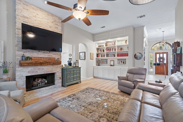 living room featuring a fireplace, light hardwood / wood-style flooring, and built in features