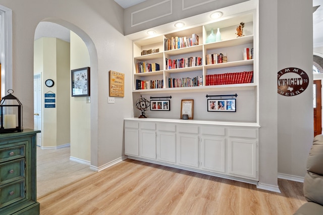 hallway with built in features and light hardwood / wood-style flooring