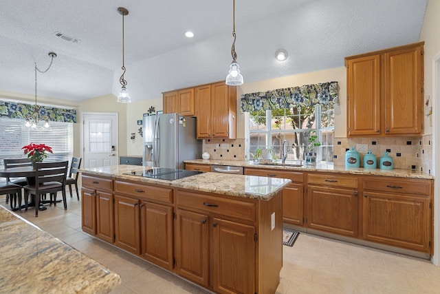 kitchen with pendant lighting, sink, vaulted ceiling, a kitchen island, and stainless steel appliances