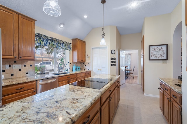 kitchen featuring black electric cooktop, sink, pendant lighting, and stainless steel dishwasher