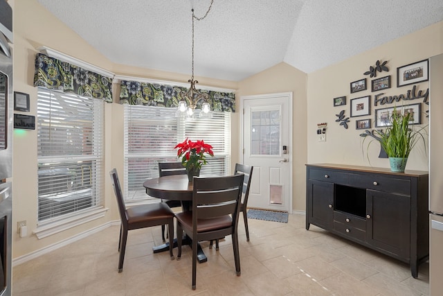 dining room featuring light tile patterned floors, a textured ceiling, an inviting chandelier, and lofted ceiling