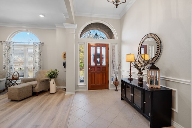 foyer entrance with ornamental molding and light hardwood / wood-style flooring