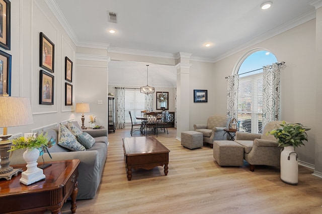 living room with ornate columns, a wealth of natural light, light hardwood / wood-style flooring, and ornamental molding