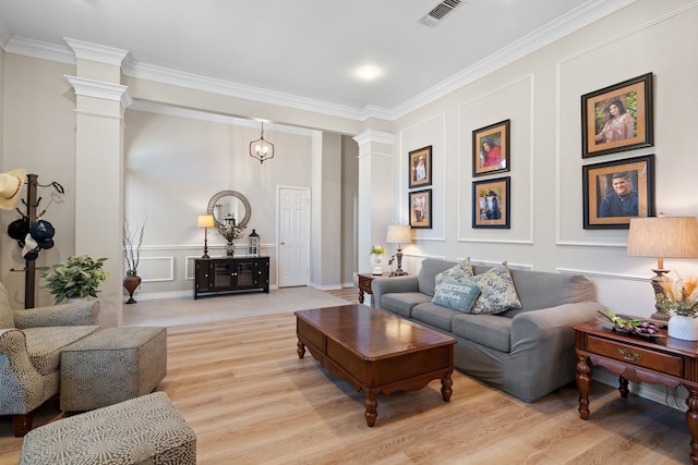 living room with light wood-type flooring, decorative columns, and ornamental molding