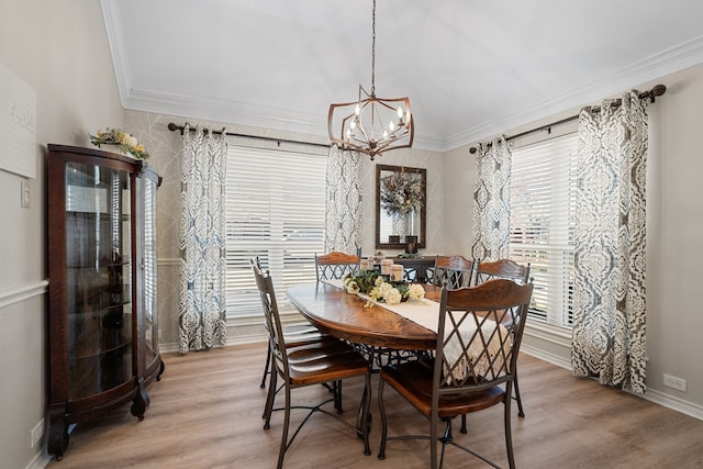 dining space with crown molding, a chandelier, and light wood-type flooring