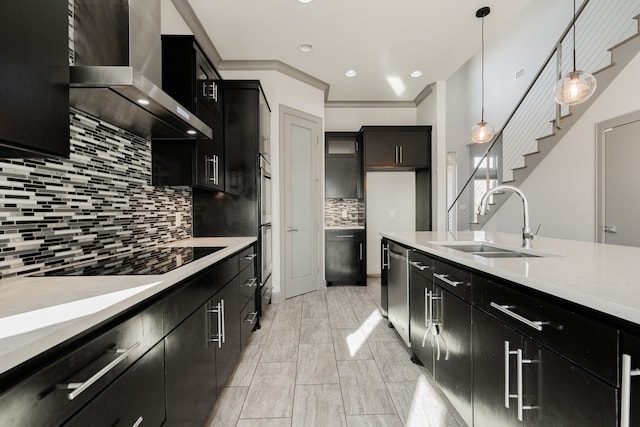 kitchen with sink, stainless steel appliances, decorative light fixtures, backsplash, and wall chimney range hood