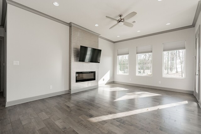 unfurnished living room featuring ceiling fan, a brick fireplace, crown molding, and wood-type flooring