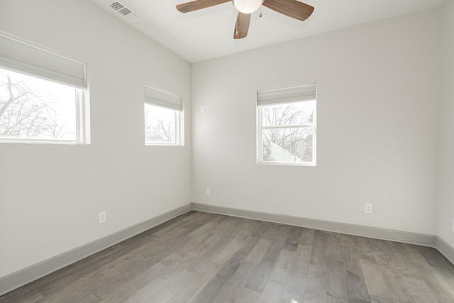 unfurnished room featuring light hardwood / wood-style floors, ceiling fan, and a wealth of natural light