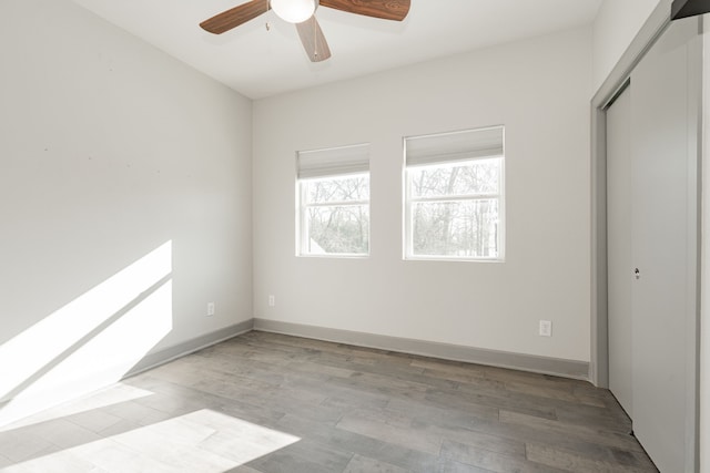 unfurnished bedroom with ceiling fan, light hardwood / wood-style flooring, and a closet