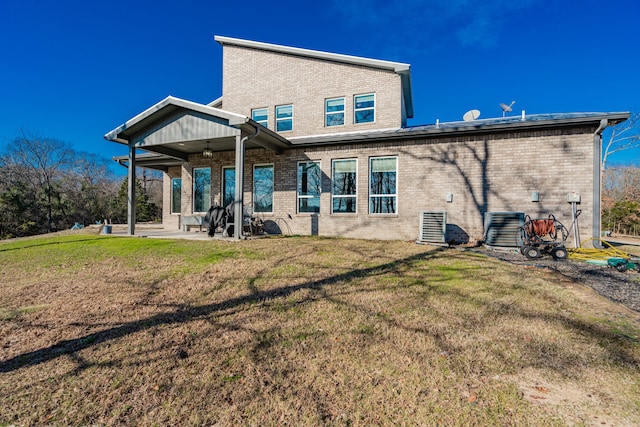 rear view of house with ceiling fan, a yard, and a patio area