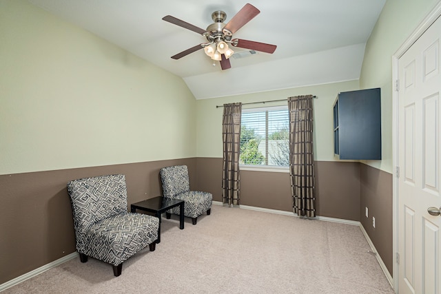 sitting room with ceiling fan, light colored carpet, and vaulted ceiling