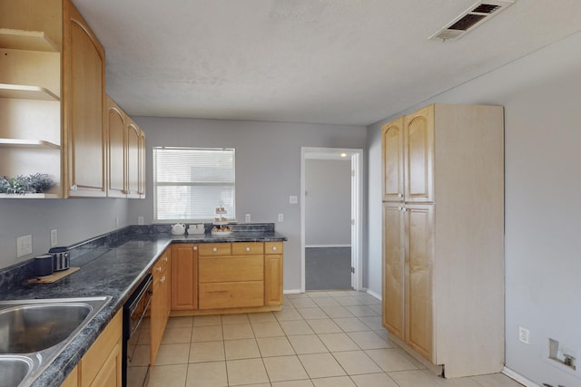 kitchen with light tile patterned floors, light brown cabinetry, dishwasher, and sink