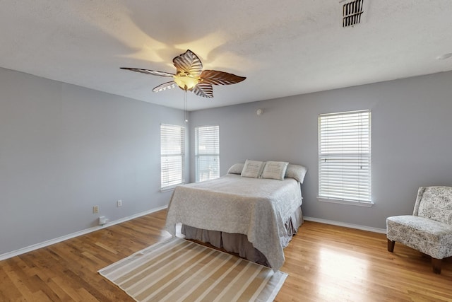 bedroom with ceiling fan and light hardwood / wood-style floors