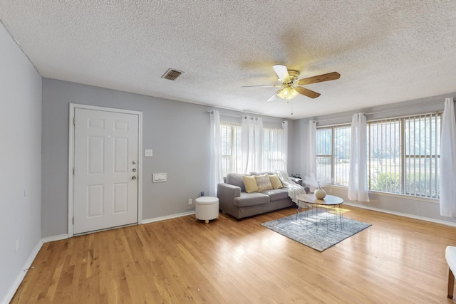 unfurnished living room with a textured ceiling, ceiling fan, and light hardwood / wood-style floors