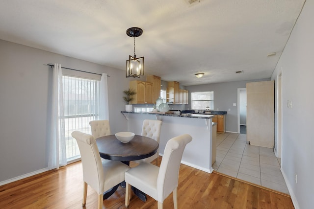 dining area featuring an inviting chandelier and light wood-type flooring