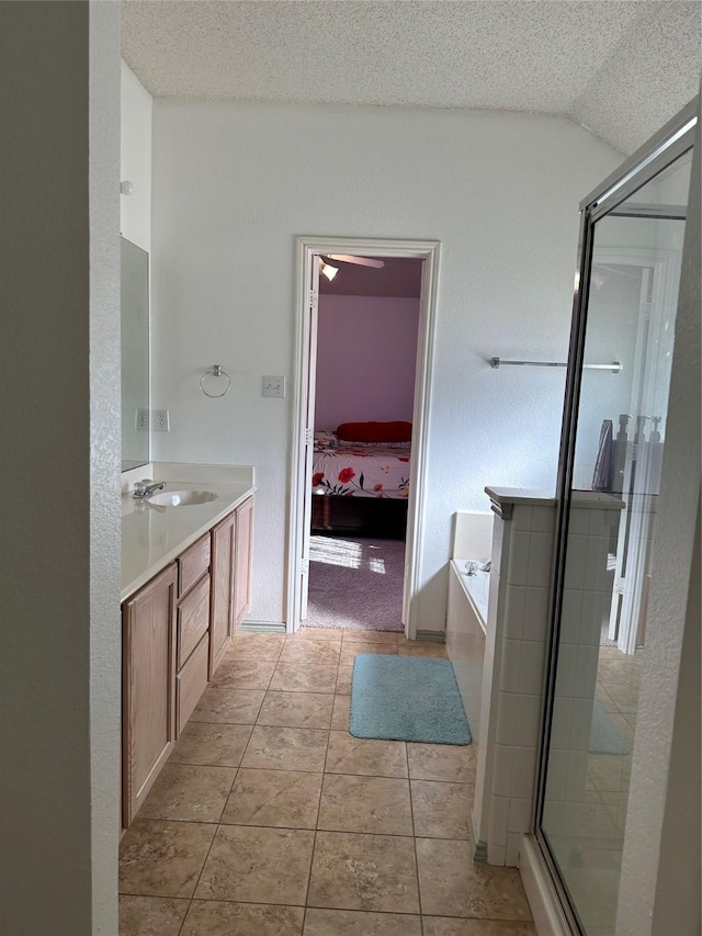 bathroom featuring vanity, tile patterned flooring, vaulted ceiling, a textured ceiling, and shower with separate bathtub