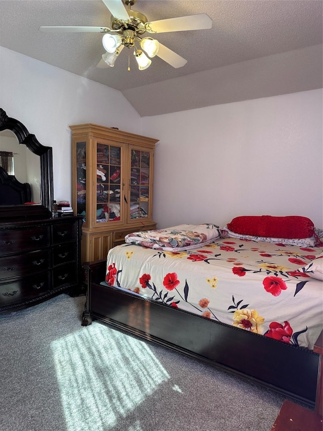 carpeted bedroom featuring ceiling fan, vaulted ceiling, and a textured ceiling