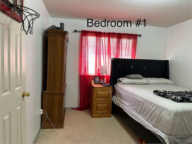 bedroom featuring light colored carpet and a textured ceiling