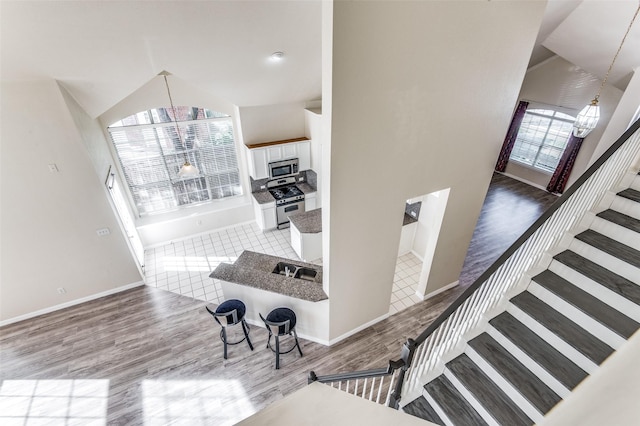 stairway with hardwood / wood-style flooring and vaulted ceiling