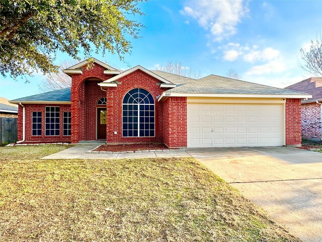 view of front of property featuring a garage and a front lawn