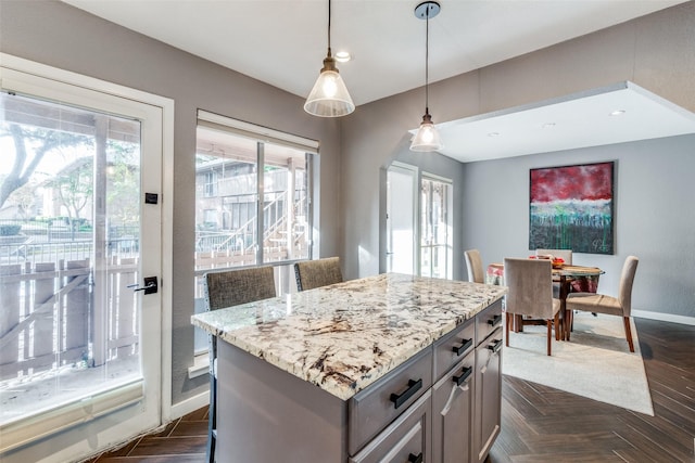 kitchen featuring pendant lighting, dark parquet flooring, and a center island