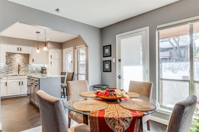 dining area with dark parquet flooring and sink