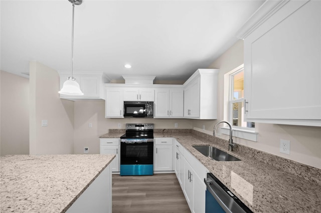 kitchen featuring sink, hanging light fixtures, stainless steel appliances, light stone countertops, and white cabinets