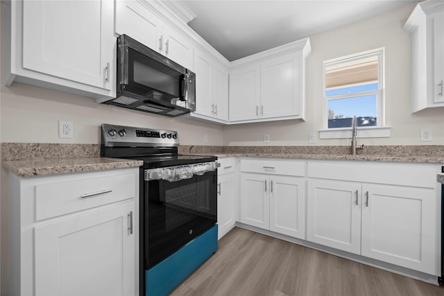 kitchen featuring stainless steel electric stove, light stone countertops, light hardwood / wood-style flooring, and white cabinets