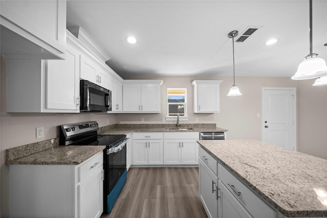 kitchen featuring black appliances, white cabinets, and hanging light fixtures